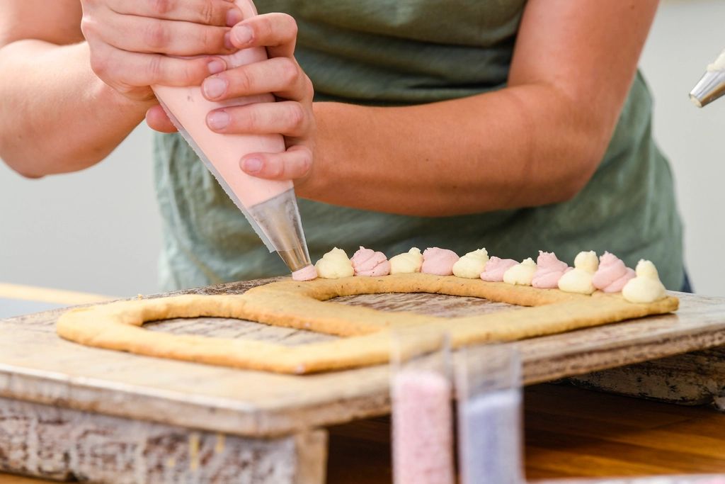 Mãos confeitando com saco de confeitar