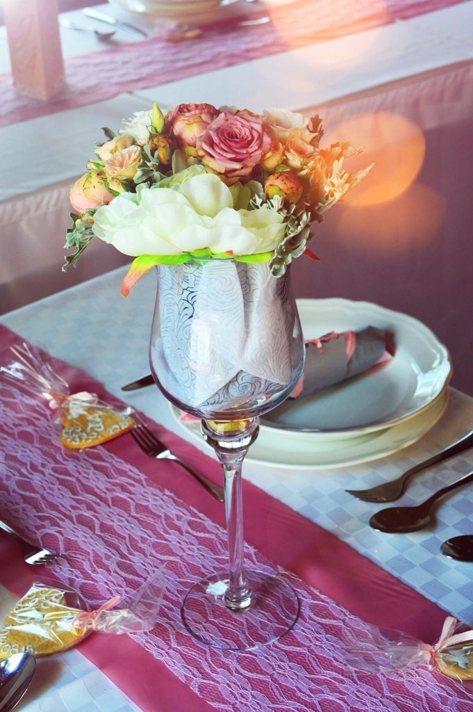 Mesa com caminho rosa, flores e taças