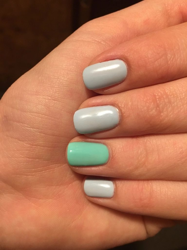 Mão com unhas em tons de menta e cinza claro